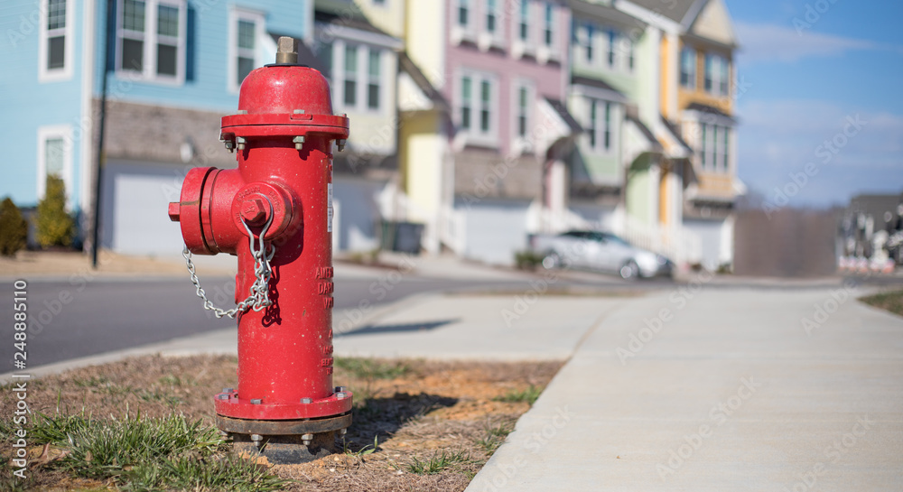 Close up bokeh shot of a bright red fire hydrant with brightly colored townhouses in the background. Close up bokeh shot of a bright red fire hydrant with brightly colored townhouses in the background.