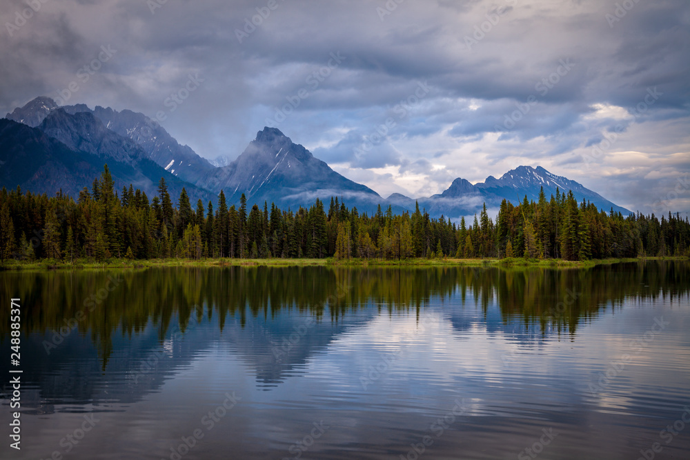 Mountains reflecting in the calm waters of Spillway Lake in Peter Lougheed Provincial Park, Alberta, Canada