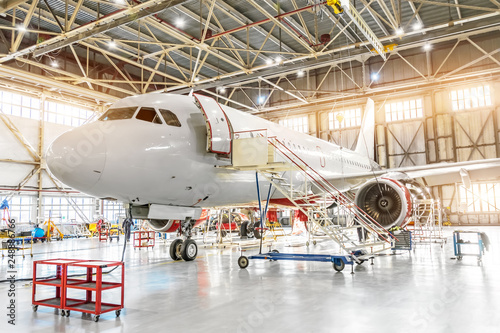 Aviation hangar with passenger aircraft jet for maintenance.