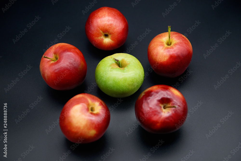 Five red apples and green on black background Five red apples and green on black background