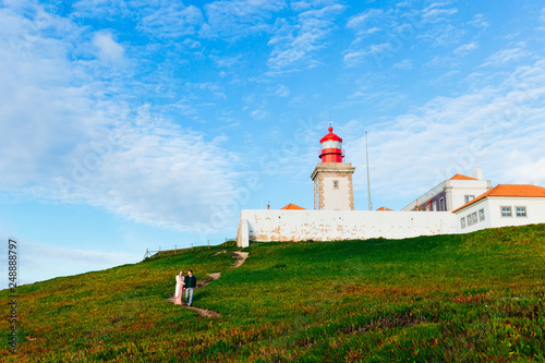 beautiful lighthouse. the couple in love walking on the path nea