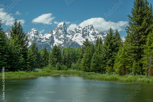 Grand Teton Range Framed  by Trees with Lake in Foreground © davelafontaine