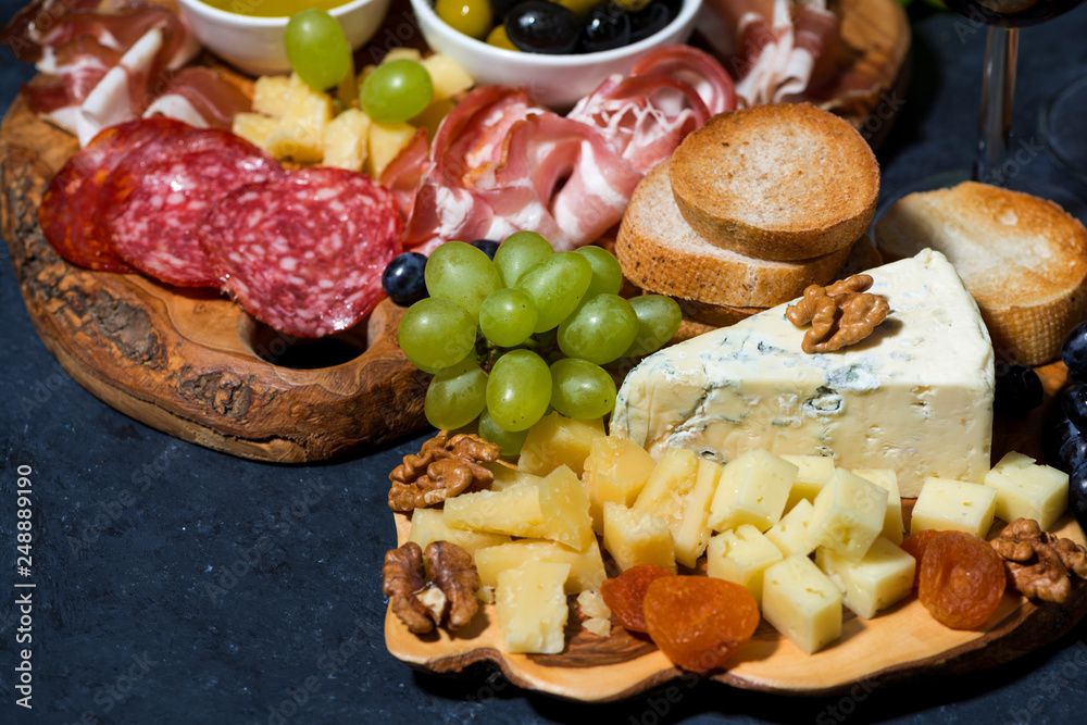 cheese platter on a wooden board, bread, fruit and cold cuts cheese platter on a wooden board, bread, fruit and cold cuts