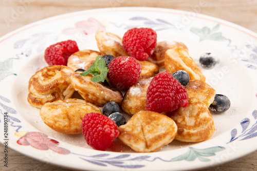 Pancakes, poffertjes with blueberries, raspberries and sugar
