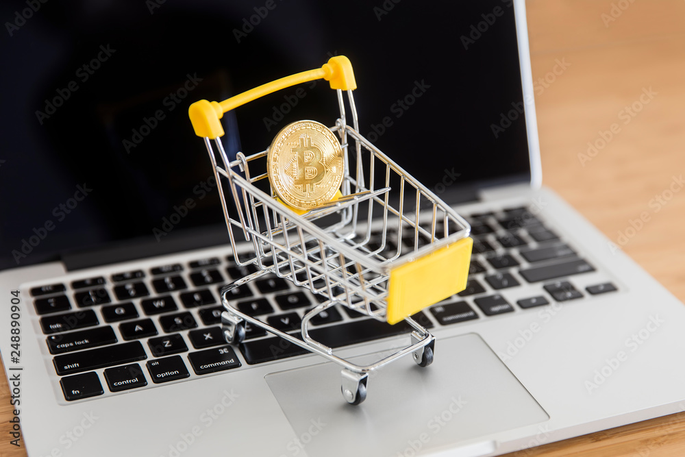 Cryptocurrency bitcoin in mini supermarket trolley on laptop