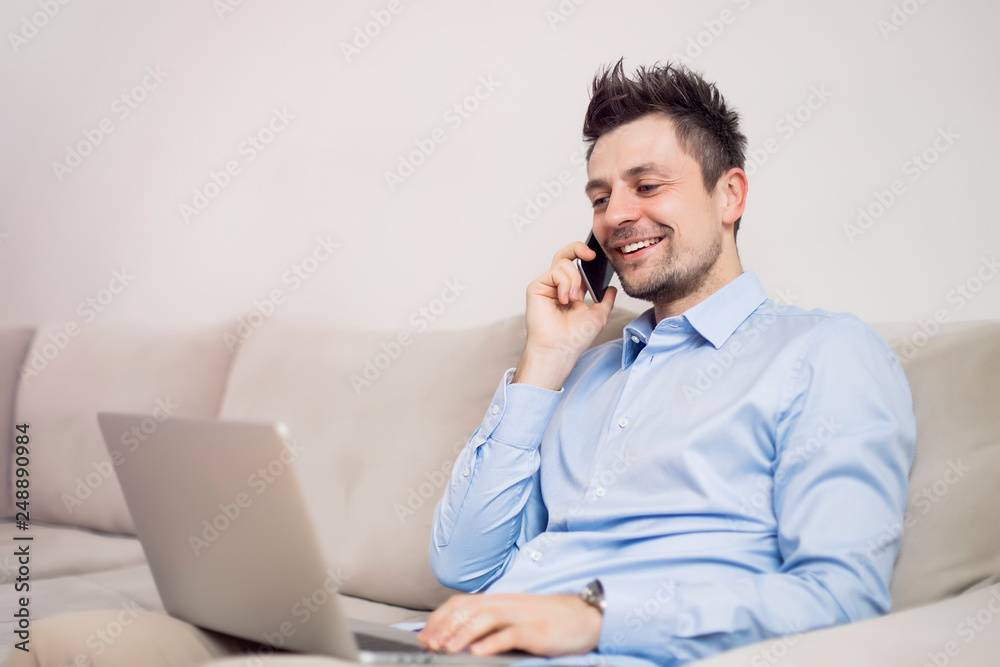 Young businessman using mobile phone and working on laptop Young businessman using mobile phone and working on laptop