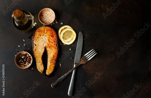 grilled salmon steak with ingredients on concrete background