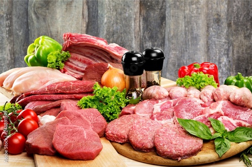 Fresh raw meat background with vegetables on wooden desk isolated on white background