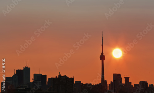 Toronto s skyline lit by sun raising behind the buildings