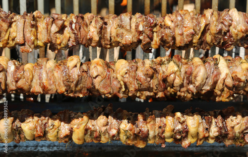 spit with chicken meat and pork cooked in the rotisserie