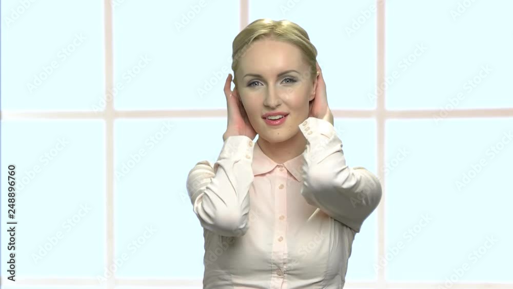 Flirty european woman touching her hair. Seductive blonde business woman looking at camera playfully. Checkered window background. Flirty european woman touching her hair. Seductive blonde business woman looking at camera playfully. Checkered window background.