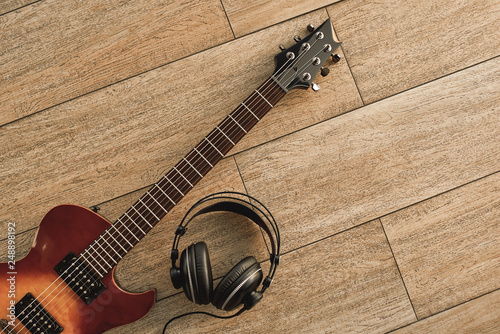 Guitar recording. An electric guitar and professional headphones on a wooden floor photo