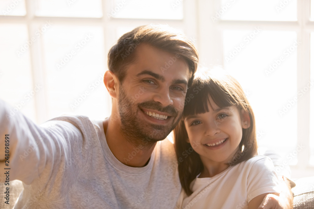 Dad and kid daughter with happy faces posing taking selfie