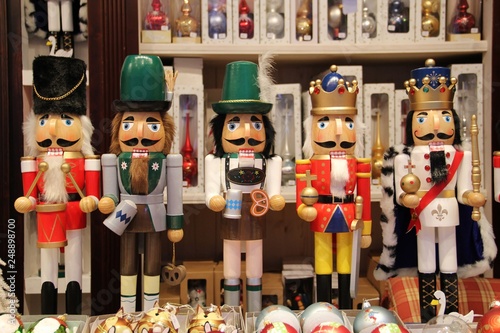 Bavarian nutcrackers and British nutcracker dolls at Christmas market in Munich, Germany. Decorative wooden figurines resemble toy soldiers, kings or oktoberfest locals. Toys or Ore Mountain souvenirs
