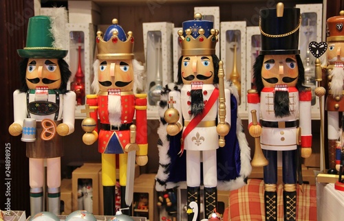Bavarian nutcrackers and British nutcracker dolls at Christmas market in Munich, Germany. Decorative wooden figurines resemble toy soldiers, kings or oktoberfest locals. Toys or Ore Mountain souvenirs
