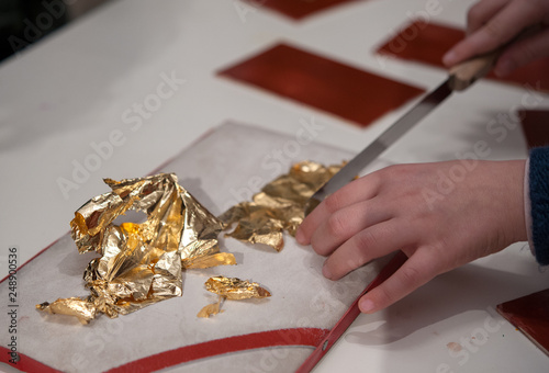 Craftsman cuts an extremely thin gold leave for the gilding tecnique.