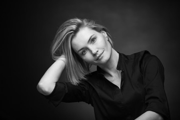 Dramatic black and white portrait of a beautiful woman on a dark background
