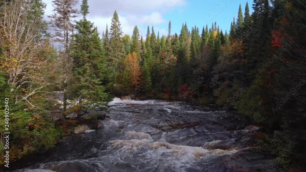 Aerial, drone shot, over river rapids, in between autumn color forest, on a cloudy, fall day, near Mont-Tremblant national park, Quebec, Canada Aerial, drone shot, over river rapids, in between autumn color forest, on a cloudy, fall day, near Mont-Tremblant national park, Quebec, Canada