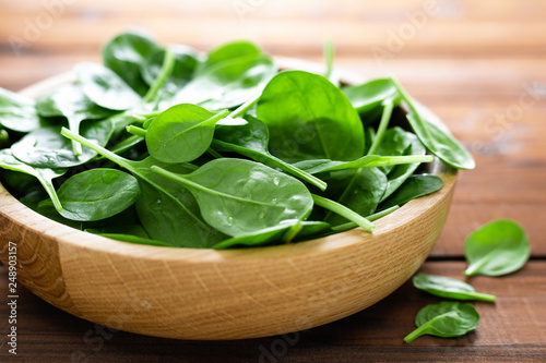 Fresh spinach leaves on wooden background. Healthy vegan food