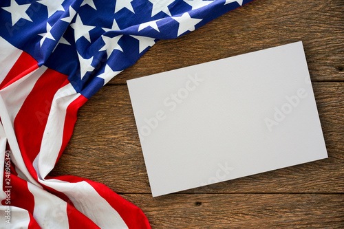 close up on mock up white paper texture with vintage crumpled retro of America flag on wood table top background for design concept photo