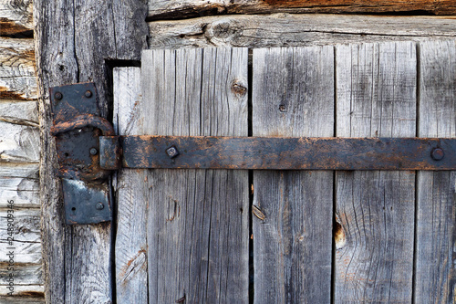 rusty aged iron hinge on old wooden door