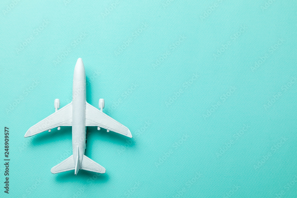 White passenger plane on green mint background. Copy space for text. White passenger plane on green mint background. Copy space for text.