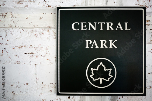 A wall with a dark green sign of central park