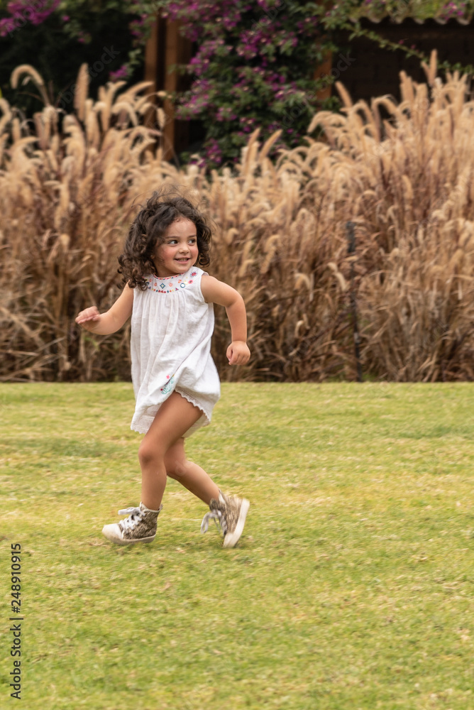 Beautiful girl trying to escape in a playful way. Hide and seek game in a candid portrait