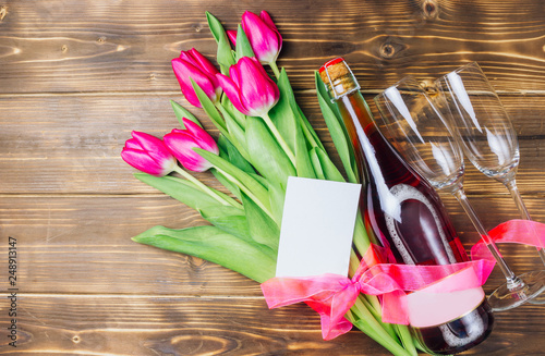 Tulips, champagne bottle and two empty glasses