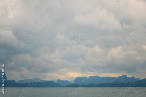 Seascape with a cloudy sky and a rocky coastline on the horizon