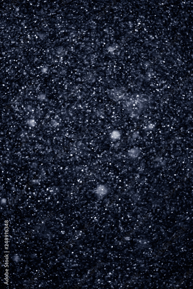 Obraz premium Artificial snow falling on a black background as overlay