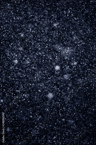 Artificial snow falling on a black background as overlay