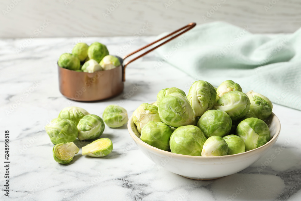 Bowl with fresh Brussels sprouts on marble table. Space for text Bowl with fresh Brussels sprouts on marble table. Space for text