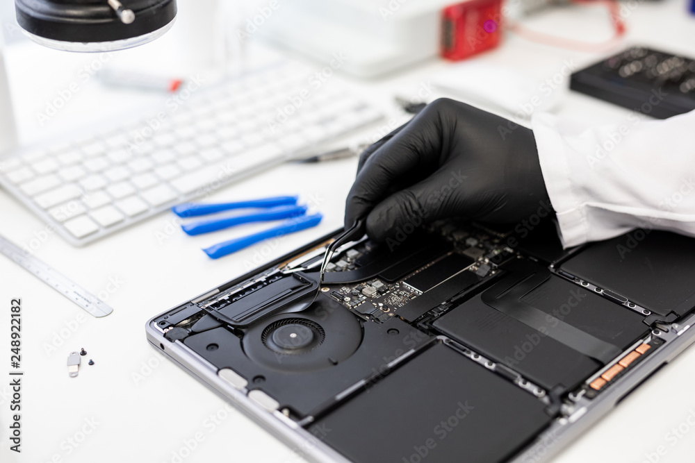 Obraz premium Closeup of a hand of Engineer fixing broken part of digital tablet