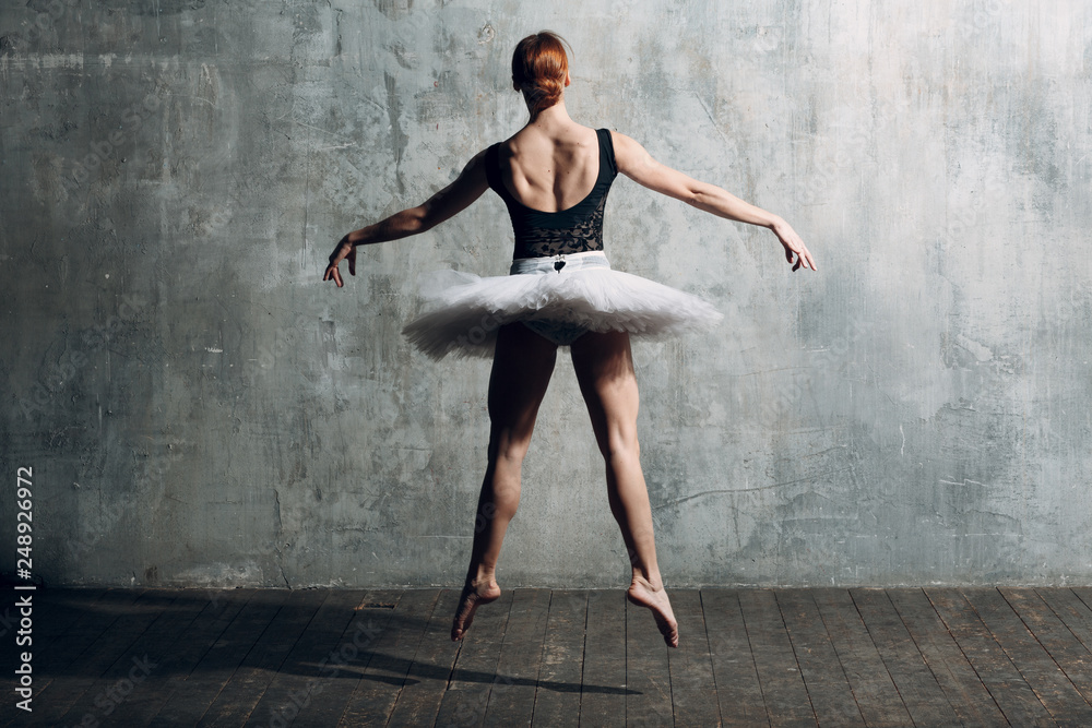 Ballerina female. Young beautiful woman ballet dancer, dressed in professional outfit, pointe shoes, black top and white tutu.