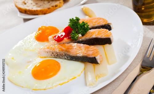 Delicious grilled salmon with eggs, tomatoes, asparagus and parsley