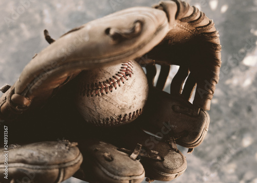 Photography Old baseball in leather glove close up with grunge style image.
