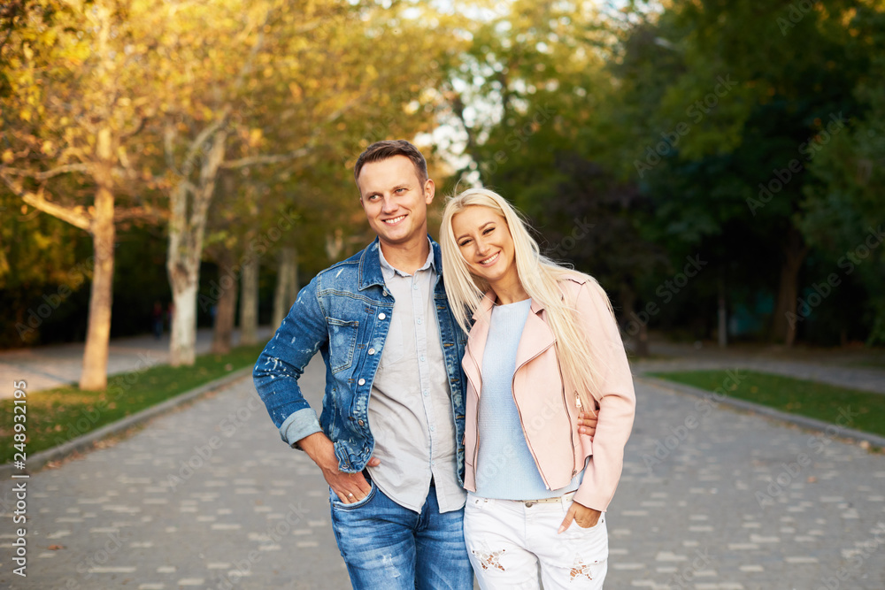 Happy young couple in love hugging and laughing outdoors. Walking in the sunny park Happy young couple in love hugging and laughing outdoors. Walking in the sunny park