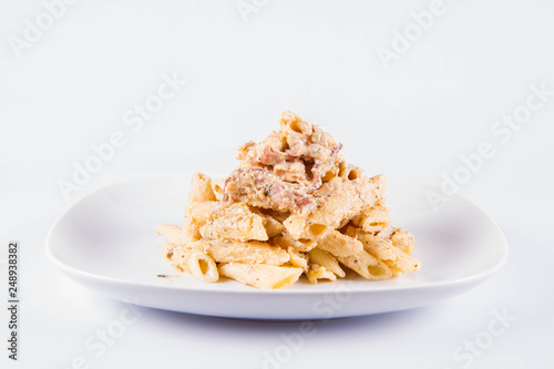 Pasta - penne with cream sauce with bacon on a plate