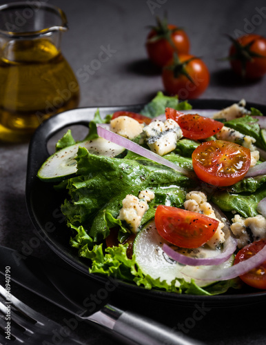 Fresh green salad with blue cheese, onions and cherry tomatoes