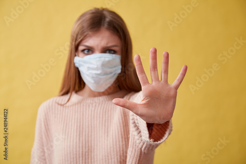 Young ill woman on isolated background. Girl in medical mask. © oleg_chumakov