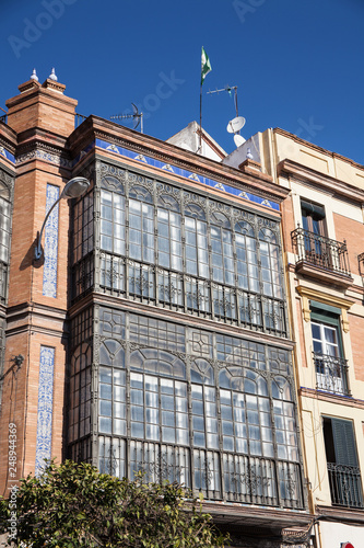 Hausfasade in Triana, Sevilla mit verglasten Balkonen photo