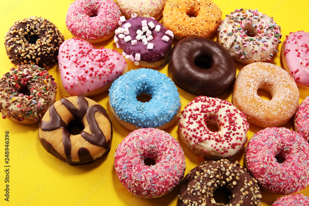 assorted donuts with chocolate frosted, pink glazed and sprinkles donuts