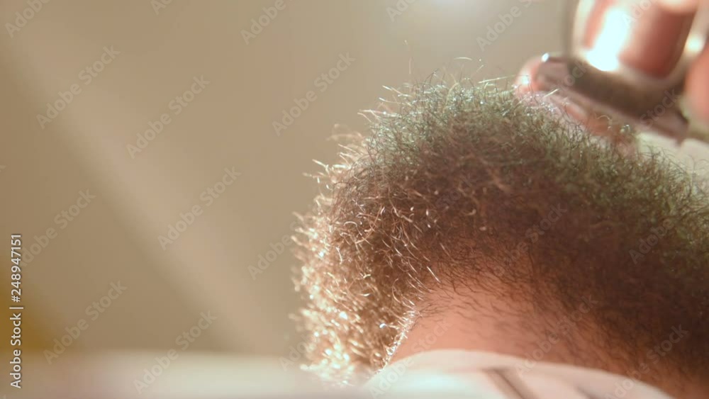 Barber shaves the client's beard with an electric razor or a close-up trimmer Barber shaves the client's beard with an electric razor or a close-up trimmer