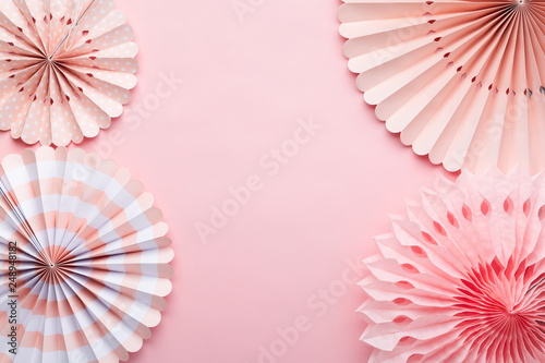 Chinese paper fans in pastel colors on pink table  top view  copy space for text  selective focus