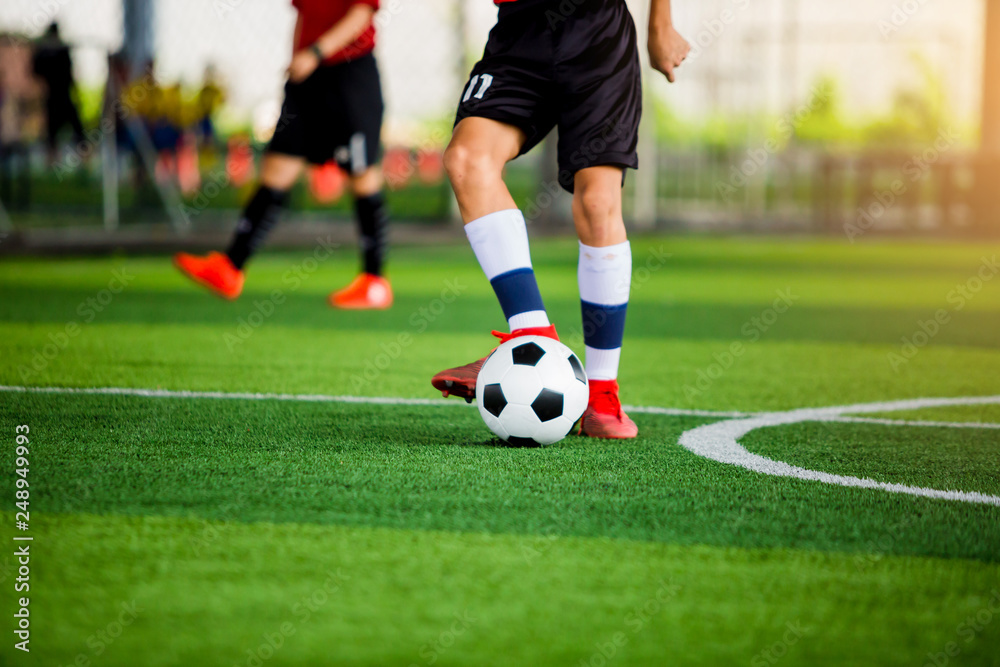 Blurry ball after soccer player shoot it on green artificial turf