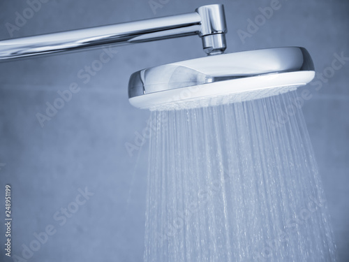 Flowing water from shower head at bathroom interior