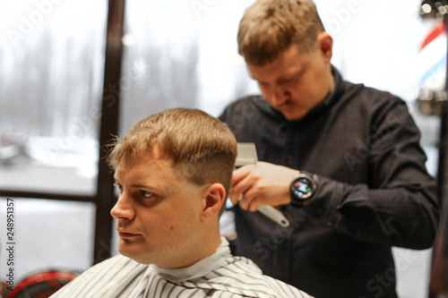 man in barbershop making a new hairdresser with barber 