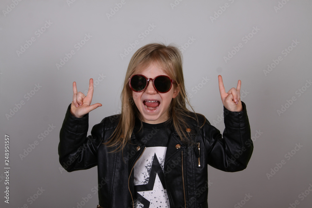 Portrait of a heavy metal little girl with sunglasses. Cute little girl