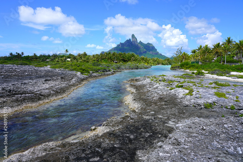 View of the Mont Otemanu mountain seen from the water over the reef between the ocean and the lagoon in Bora Bora, French Polynesia, South Pacific